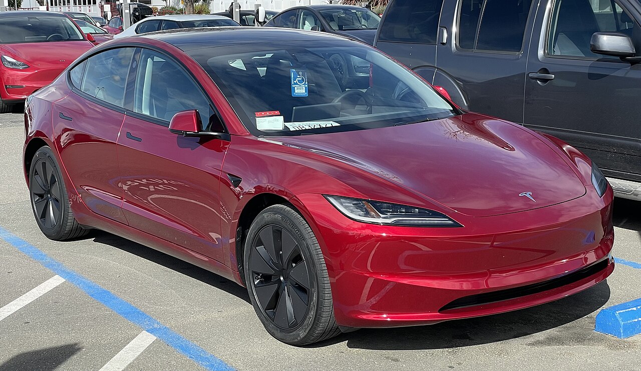 Tesla Model 3 rojo de la generación actual, fotografiado de frente y de lado